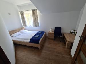 a bedroom with a bed and a desk and a chair at Pod Laskiem in Krośnica