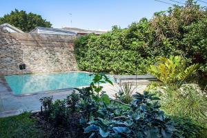 una piscina en un jardín con plantas en Colourful Coogee en Sídney