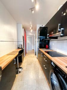 een keuken met een wasmachine en droger. bij EXIGEHOME - Bel appartement à 500 m des JOs équitation - Piscine et tennis in Le Chesnay