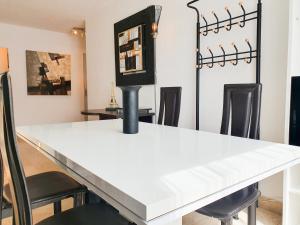 een eetkamer met een witte tafel en stoelen bij EXIGEHOME - Bel appartement à 500 m des JOs équitation - Piscine et tennis in Le Chesnay