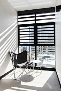 a black chair and a table in front of a window at Cosmopolitan Heights in Sydney