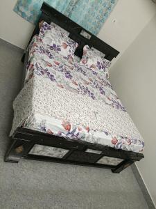 um quarto com uma cama com um edredão florido em SREENIVASA HOME STAY em Tirupati