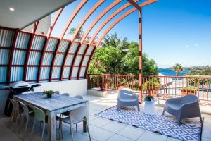 een grote kamer met een tafel en stoelen op een balkon bij Gordons Bay Vista in Sydney