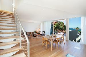 een woonkamer met een eettafel en een trap bij Gordons Bay Vista in Sydney