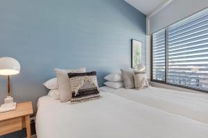 Un dormitorio con una gran cama blanca y una ventana en Coogee Bay Penthouse, en Sídney
