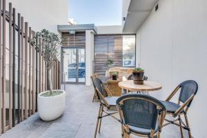 un patio con sillas, una mesa, una mesa y una planta en Coogee Bay Penthouse, en Sídney