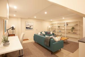 een woonkamer met een blauwe bank en een tafel bij Gordons Bay Vista in Sydney
