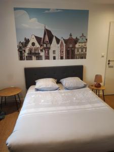 Bett in einem Zimmer mit Wandgemälde in der Unterkunft APPART'HOTEL EDEN in Béthune
