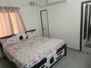um quarto com uma cama com um edredão preto e branco em SREENIVASA HOME STAY em Tirupati