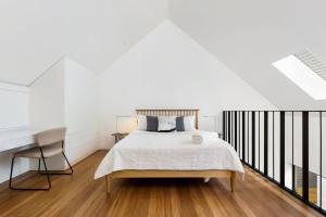 een witte slaapkamer met een bed en een bureau bij The Loft in Sydney
