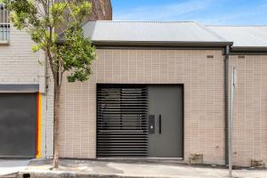 een bakstenen gebouw met een garage met een deur bij The Loft in Sydney