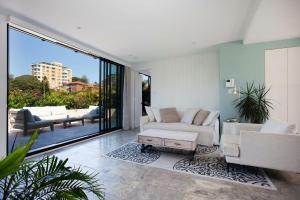 uma sala de estar com dois sofás e uma mesa em The Treehouse Penthouse em Sydney
