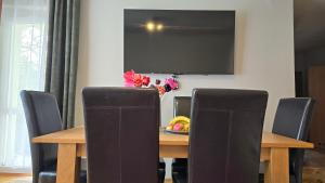a dining room table with chairs and a television on the wall at Apartamenty Straconka ,Bielsko-Biala in Bielsko-Biala