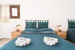 een slaapkamer met een blauw bed met 2 kussens erop bij S' Istancu Vetzu in Irgoli