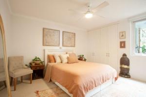 um quarto com uma cama, uma cadeira e uma janela em La Brisa Coogee em Sidney