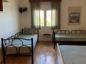 1 dormitorio con 2 camas y ventana en The Family Place - Cosy Double bedroom apartment on beach of Kallithea, Chalkidiki, en Kallithea Halkidikis