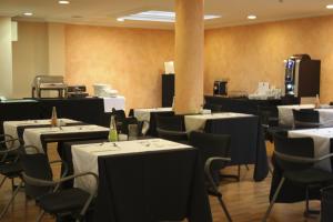 une salle à manger avec des tables, des chaises et un tissu de table blanc dans l'établissement Hotel Abbot, à Barcelone