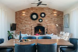 a dining room with a brick wall with a fireplace at Embracing Evandale in Evandale