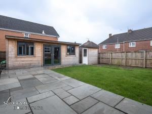 a backyard with a lawn and a house at Spacious 3 bed with outdoor games room & private parking in Gateshead