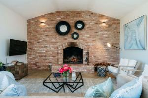 sala de estar con pared de ladrillo y chimenea en Embracing Evandale, en Evandale