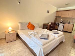 a large bed in a room with a kitchen at Utopia Apartments Primorsko in Primorsko