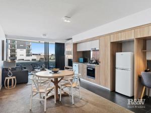 kuchnia i salon ze stołem i krzesłami w obiekcie One Oak w mieście Brisbane