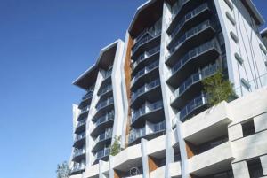 a tall apartment building with plants on the balconies at One Oak in Brisbane