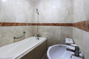 bagno con lavandino e vasca di Jambrut Inn a Giacarta