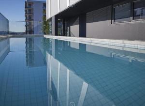 a swimming pool next to a building at One Oak in Brisbane