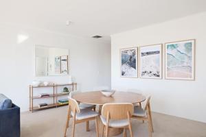 uma sala de jantar com mesa e cadeiras em Palm Breeze in Coogee em Sydney