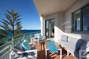 een balkon met banken en uitzicht op de oceaan bij Palm Breeze in Coogee in Sydney