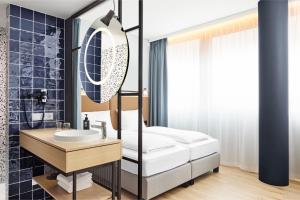 un bagno con lavandino e specchio di H2 Hotel Wien Schönbrunn a Vienna