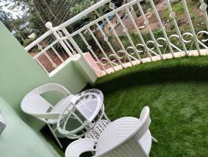 a balcony with a table and chairs and a railing at Elite stay in Embu