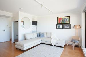 a white living room with a white couch and a rug at Ocean view Clovelly in Sydney