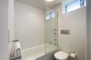 a bathroom with a tub and a toilet and a sink at Ocean view Clovelly in Sydney +15 photos
