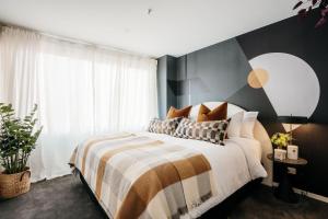 a bedroom with a bed with a black and white blanket at Midnight Moonshine Loft in Launceston