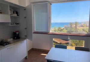 a kitchen with a table and a large window at Il Grecale case vacanza in Crotone