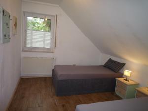 a small bedroom with a bed and a window at Ferienwohnung Alte Kämpe in Heede