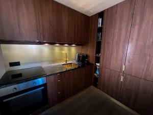 uma cozinha com armários de madeira e um forno com placa de fogão em Stor Leilighet Med 4 Soverom em Sandefjord