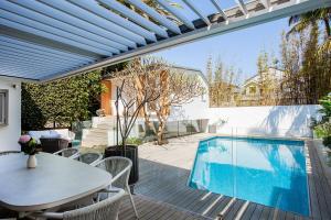 patio con tavolo e piscina di The Cali Beach house Bronte a Sydney