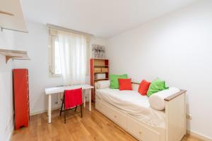 a bedroom with a bed with green and red pillows at Plenilunio Arcaute in Madrid