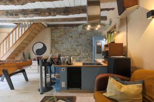 una cucina e un soggiorno con parete in pietra di Gite Home Cinema Au Calme a Cléguérec