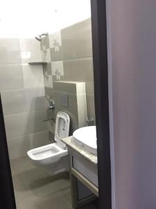 uma casa de banho com um lavatório branco e um WC. em Hotel-78 em Pithorāgarh