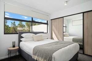 a bedroom with two beds and a large window at Queen Windsor in Brisbane