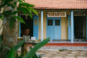 un edificio con una puerta azul con un cartel. en Thôn Hoa Sen, en Thôn Xuân Lỗ (2)