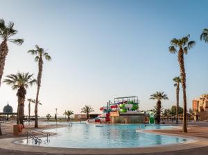 una piscina con un parque acuático con palmeras en ALEGRIA Colonial Mar en Roquetas de Mar
