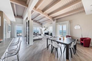 uma sala de jantar e sala de estar com mesa e cadeiras em Residenza Miralago Penthouse by Wonderful Italy em Desenzano del Garda