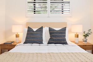 a bedroom with a bed with pillows and two lamps at Royal Redfern Isyd in Sydney