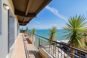 uma varanda de uma casa com vista para o oceano em Residenza Miralago Penthouse by Wonderful Italy em Desenzano del Garda