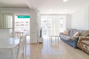 uma sala de estar com um sofá e uma mesa em Global Properties, Las dachas 1 - Apartamento en primera línea de playa em Canet d'En Berenguer